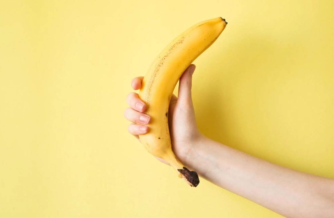 바나나 영양소 관련 바나나 하나를 들고 있는 사람 손 모습